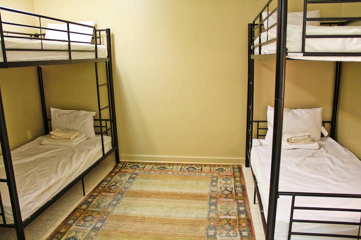 4e chambre située au niveau inférieur avec 2 lits jumeaux superposés. Combos comme buanderie, avec lave-linge, sèche-linge et comptoir pliant.