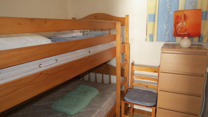 Პატარა საძინებელი ფანჯრით და ორი ორსართულიანი საწოლით 2 მ x 90 სმ