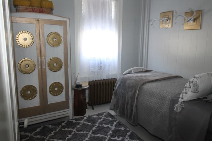 This adorable, modern meets funky bedroom is on the 2nd floor.  Its for possibly someone that can't navigate going upstairs? I painted all the furniture myself :)  The vintage armoire, the antler sheds, the side table, even the vintage bed frame.
