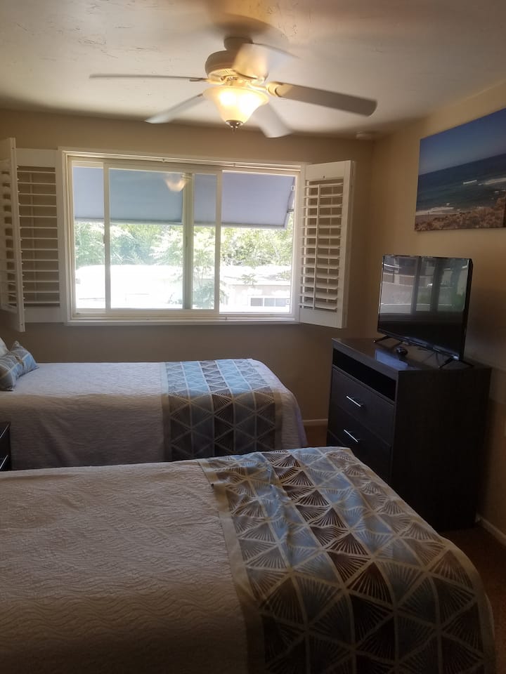 Bedroom 2 - 2 twin beds, TV, shelves, and closets.