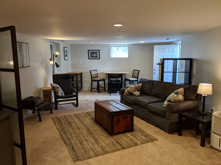 Standing at the bed in bedroom 1, looking at eating area, main entrance, and living room area.  Pretty bright and airy especially for a basement.