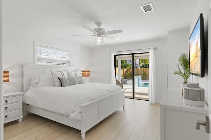 1st floor master suite. Offers pool view, slide out doors to pool access and wall mounted tv.  Every bedroom is equipped with ceiling fan as well as cotton linens including cotton duvet cover for a clean, cool, comfortable nights' sleep.