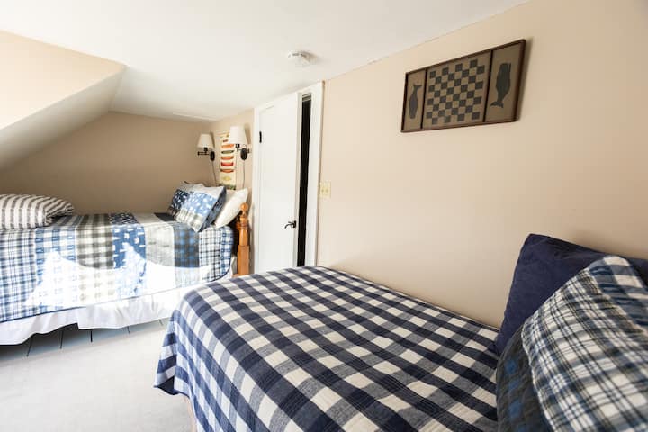 The kids room includes a full and twin beds tucked under the dormered ceilings.  It is a quiet space on the second floor of the house right next to the hallway shelves full of games and books.