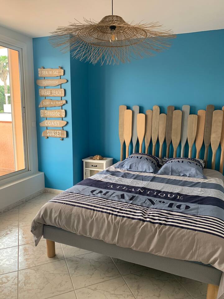 A l'étage : 
Chambre plage, élégante et décorée avec des couleurs qui font voyager !
La baie vitrée donne sur la terrasse offrant une vue sur les montagnes ! 