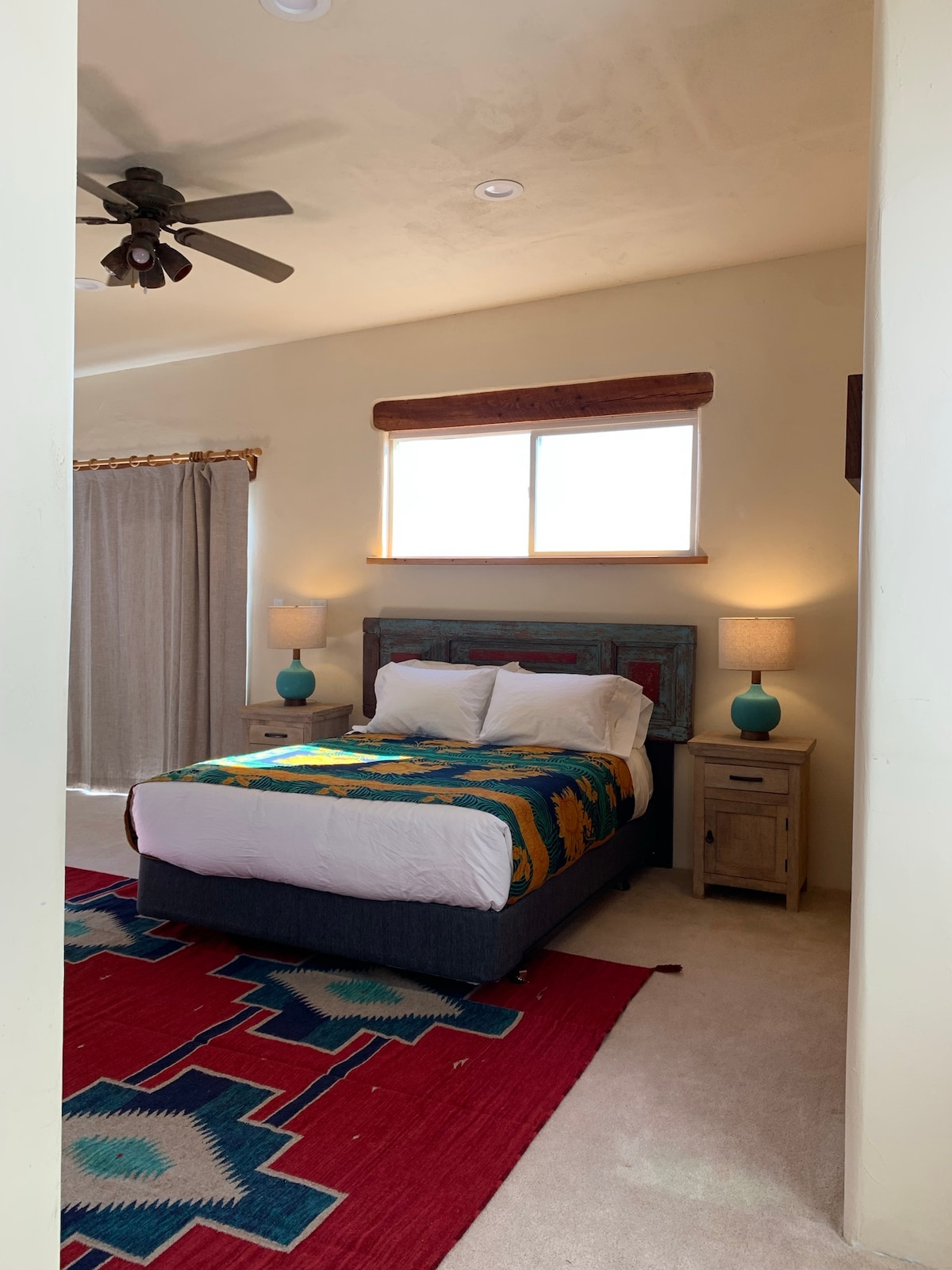 Master bedroom view from top of stairs. Curtain shields sliding glass door to one of the top-floor decks.