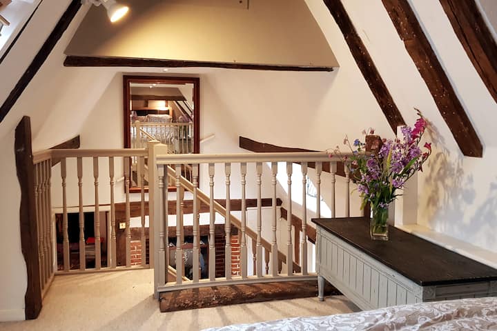 Looking from the comfortable double bed to the large sitting room. Ancient oak beams and high roof space give this room a lovely spacious feeling. Looking from mezzanine bedroom down to the sitting room with sofa bed, pull out table and chairs. 