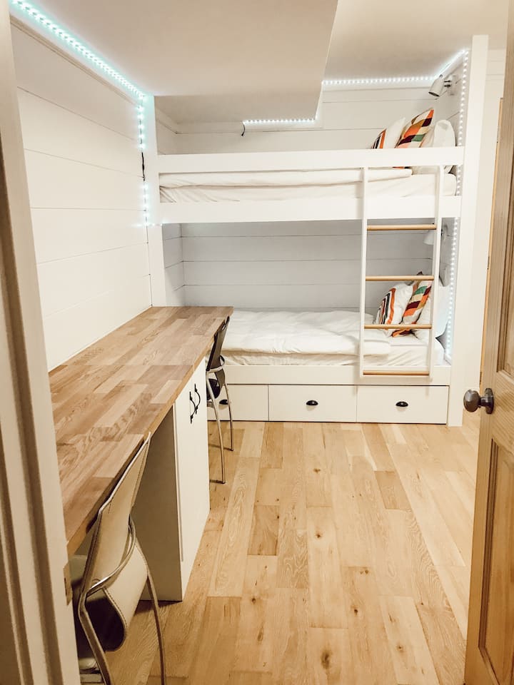 Kids bunk room with double desk and four beds