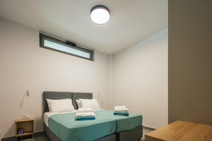 غرفة نوم في الطابق السفلي بسريرين مفردين يمكن ضمهما أيضًا معًا عند الطلب.