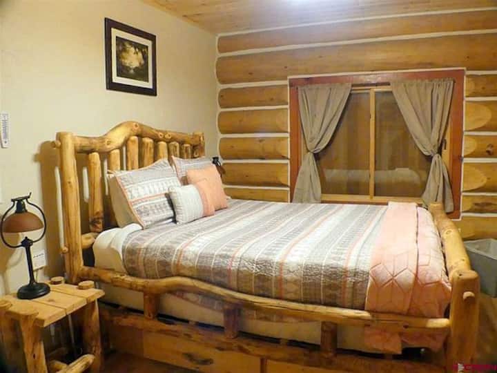 Ambas habitaciones tienen camas de tronco rústicas, mesitas de noche y muebles