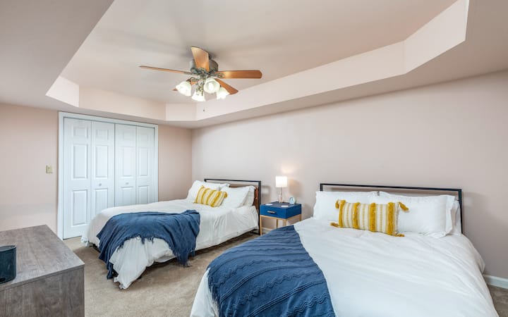 Светла и пространа спална соба со два кадифени кревета, сводест таван и удобно осветлување - идеално за мирни ноќи и заеднички престои