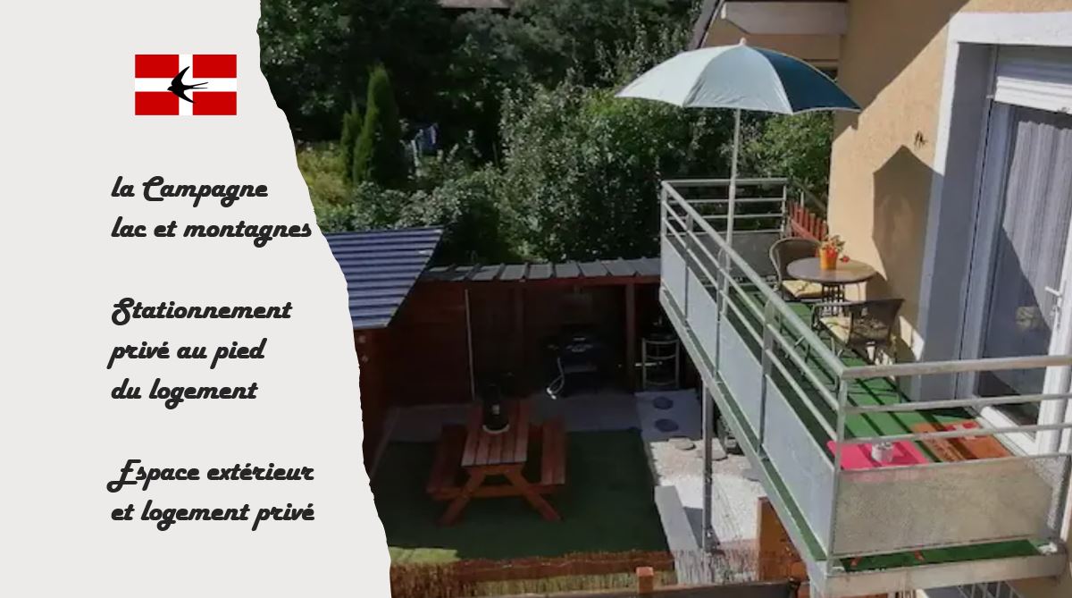 An outdoor area is visible, featuring a private balcony with an umbrella and seating. A wooden picnic table is situated in a green space, with secured boundaries surrounding the area. Parking is located nearby, offering convenience for guests.