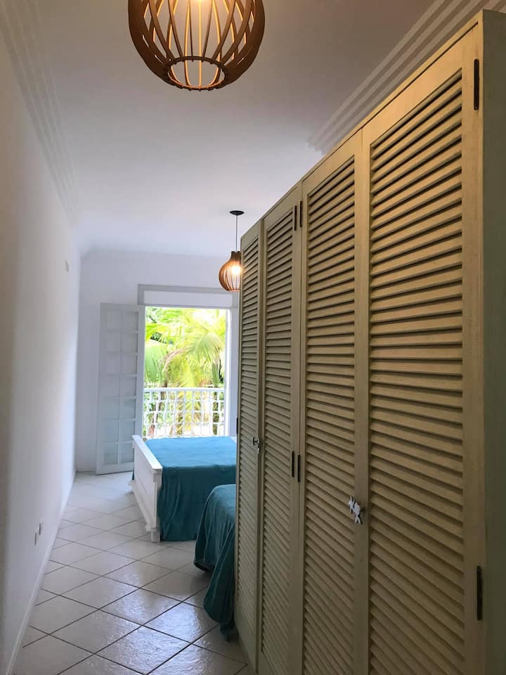 3号套房-上层-套房，配备1张标准双人床和1张单人床、空调、衣柜、遮光窗帘和房子前面的阳台。