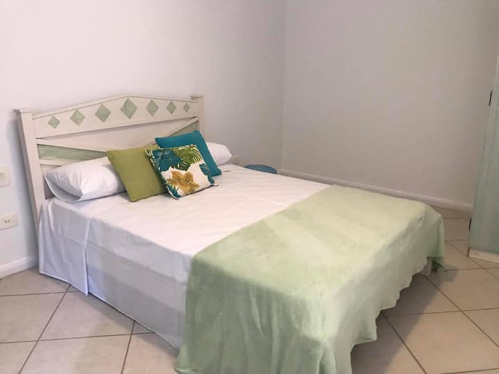 套房5 -一楼-配备1张双人床、1张单人辅助床、空调、窗帘和房屋侧走廊的窗户。