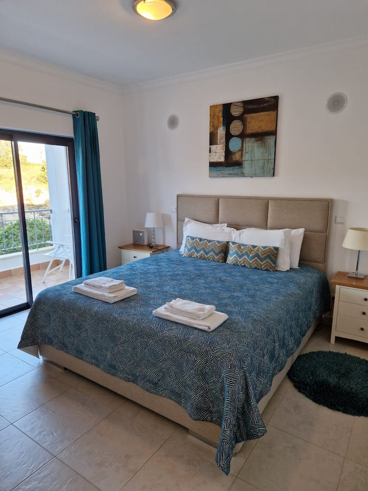 Chumba kikuu cha kulala kilicho na kitanda cha ukubwa wa mfalme, roshani ya kujitegemea na bafu la ndani