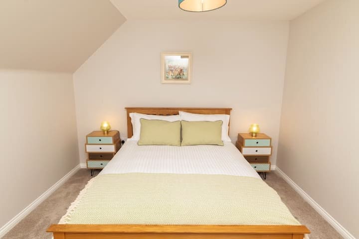 Dormitorio ubicado en el primer piso , arriba. Con cama tamaño king, tocador y taburete, y radiador controlado termostáticamente en esta habitación.