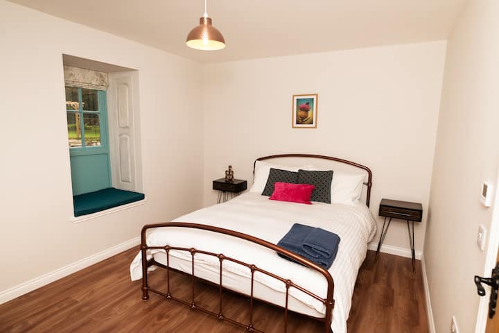 Dormitorio ubicado en la planta baja con cama tamaño king. También tiene asiento en la ventana, tocador y taburete en esta habitación. Calefacción por suelo radiante, al lado de uno de los cuartos de ducha.