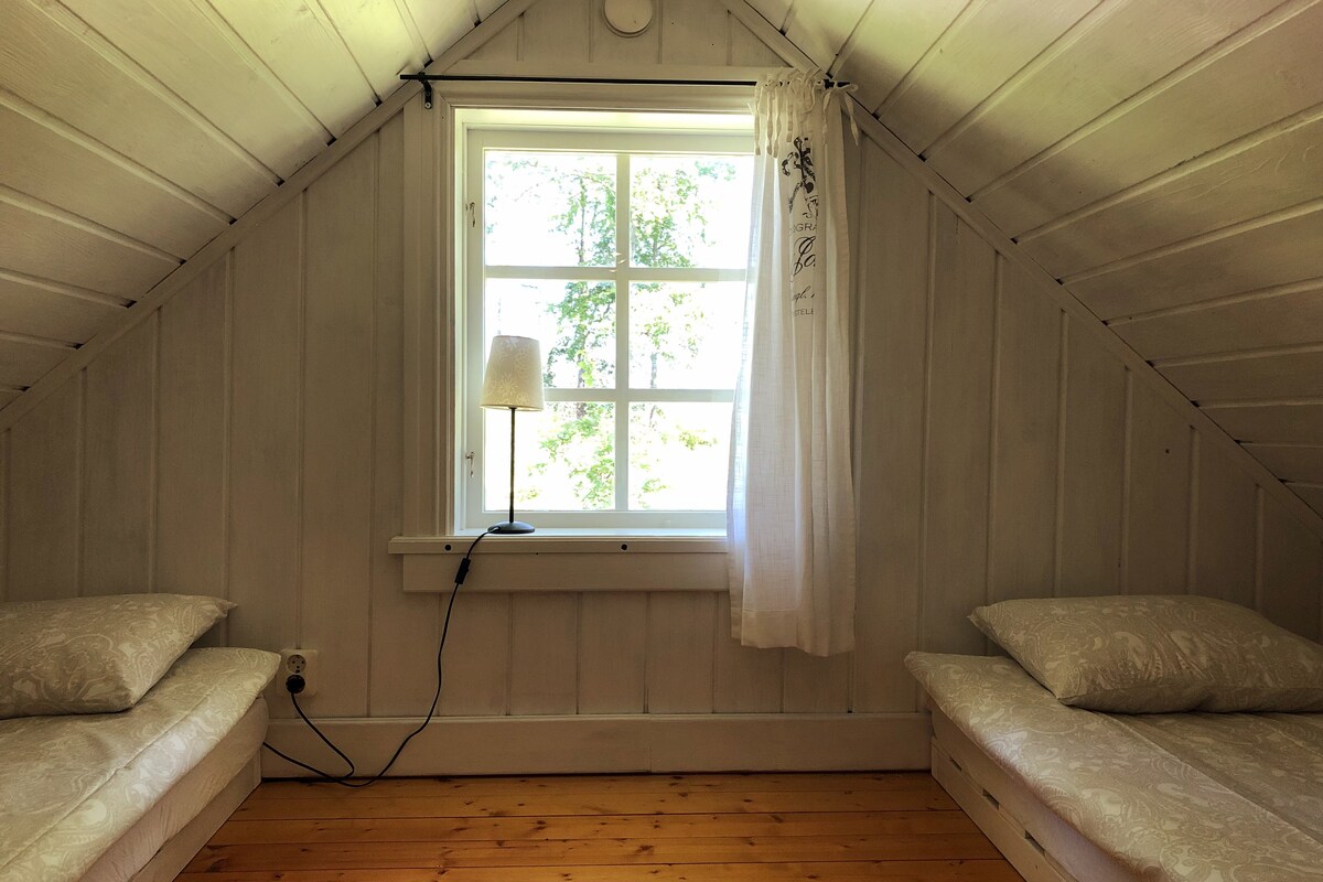 Sleeping loft with two single beds. Safety chain on the window.