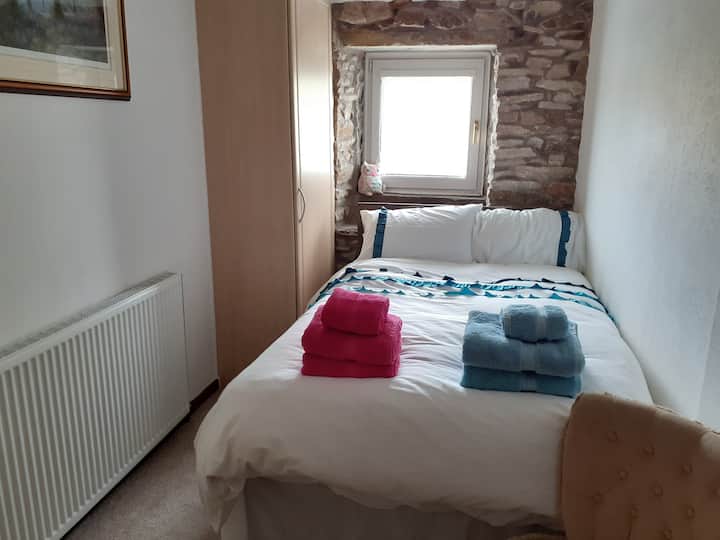 Chumba cha kulala cha pili na godoro dogo zuri la watu wawili. WARDROBE zilizofungwa. Angalia juu ya bustani ya nyuma na mashamba.