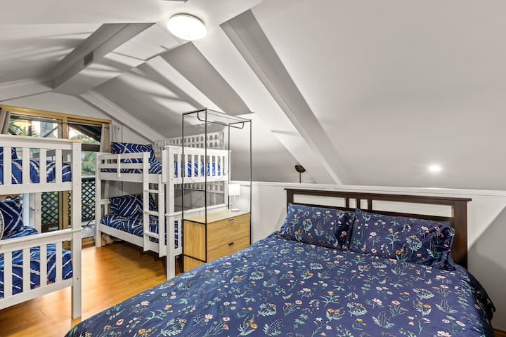 Dormitorio loft con una cama queen y 2 literas que se abren a un balcón