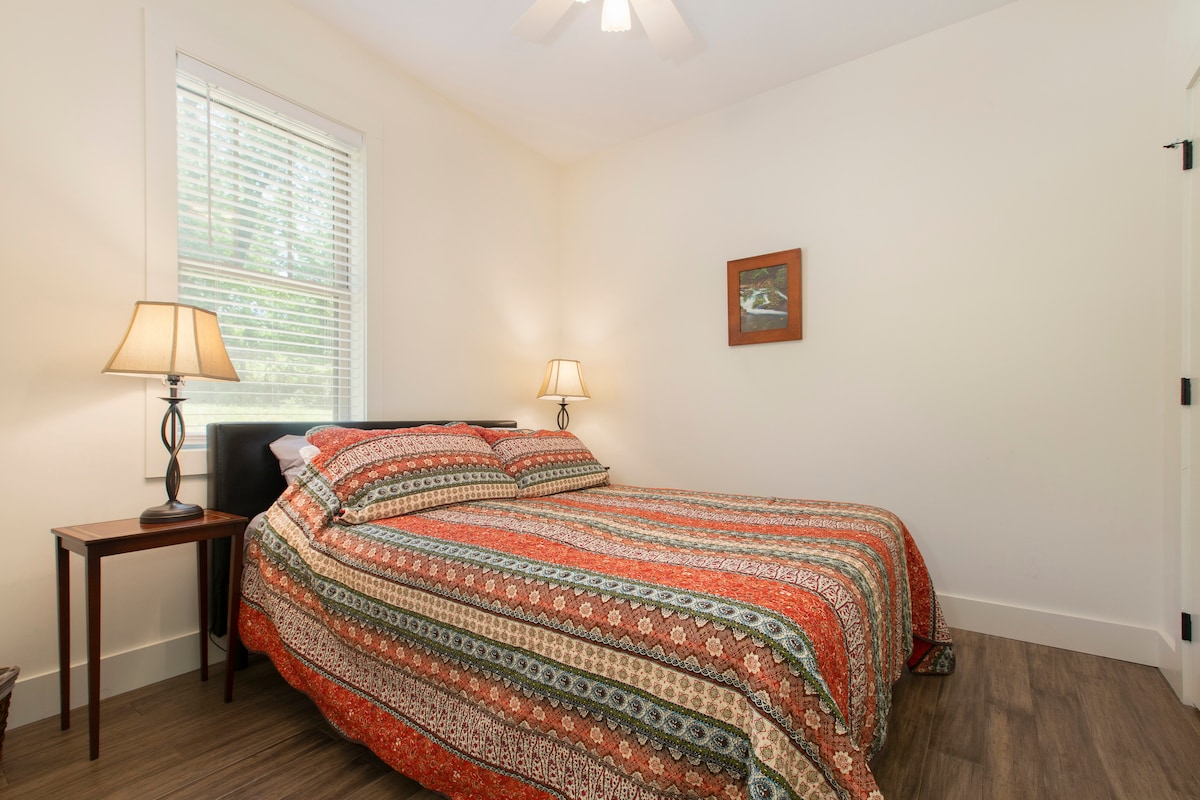 The corner guest bedroom has a queen-size bed.