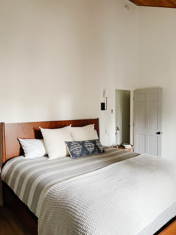 The master bedroom is on the second floor and has an en suite bathroom with a full soaking tub and shower. It has a king-size bed, dresser for clothing storage as well as a large closet where hangers and luggage rack are provided. 