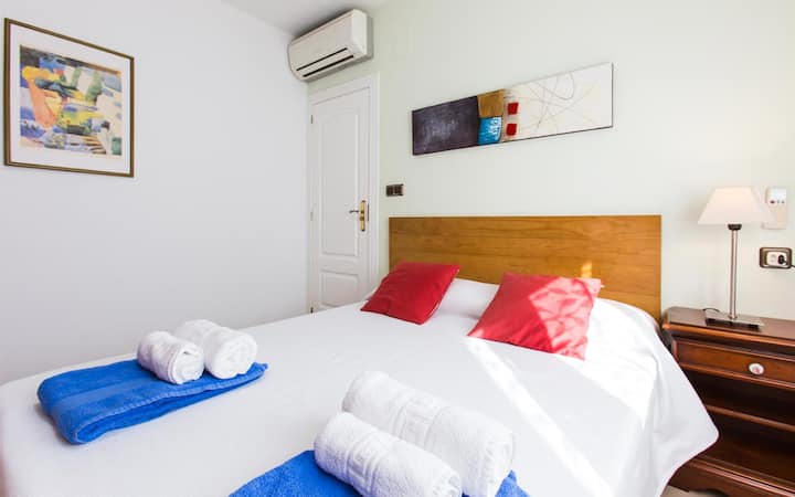 Amplio dormitorio con cama doble y ventana con vistas al exterior. 