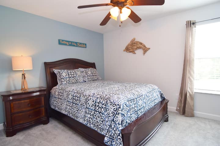 ห้องนอนควีนไซส์พร้อมธีมทะเลพัดลมเพดานและสมาร์ททีวีห้องน้ำอยู่ติดกัน