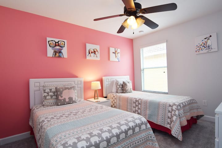 ห้องนอนเตียงแฝดสีสันสดใสพร้อมทีวีอัจฉริยะและพัดลมเพดาน