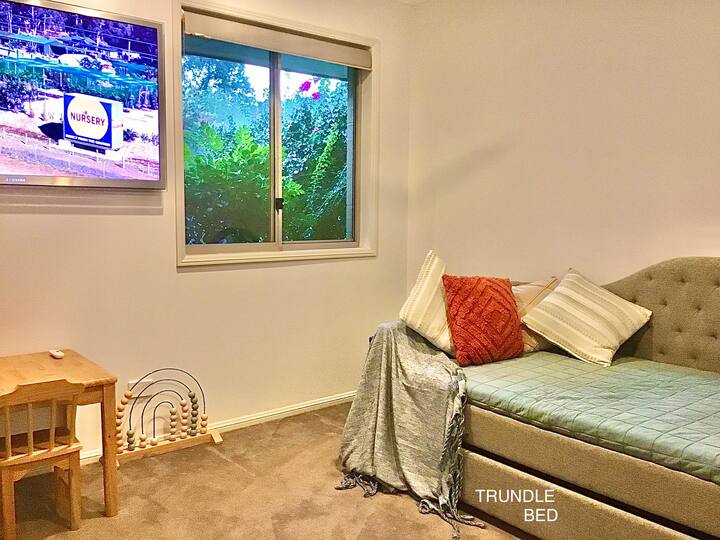 3rd bedroom for the kids - with garden outlook, blockout blinds and single daybed with trundle bed underneath, fan and Smart TV including Netflix.
