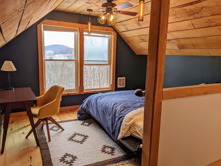 Chambre loft à l'étage avec espace de travail et vue sur le lac en hiver,  placard et salle de bain attenante.