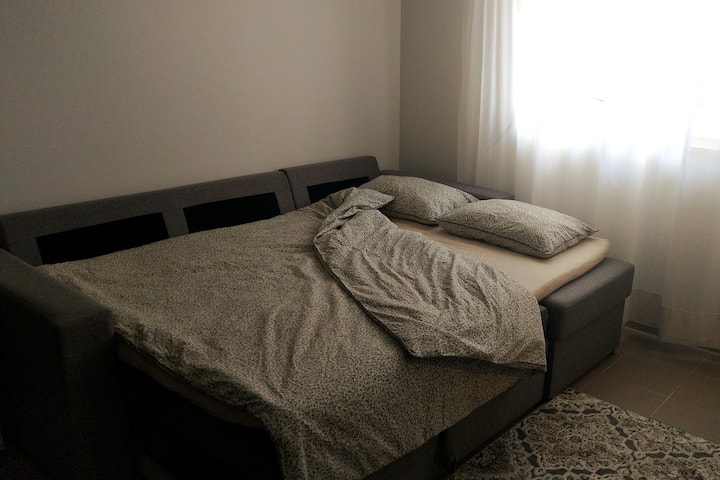 Divani mund të shndërrohet në një krevat të rehatshëm me një gjerësi 140 cm dhe një gjatësi prej 200 cm. Nuk ka gjerësi të madhe, mund të përqafohesh mirë. Ka edhe një batanije shtesë në apartament nëse është më e rehatshme të flesh veçmas.