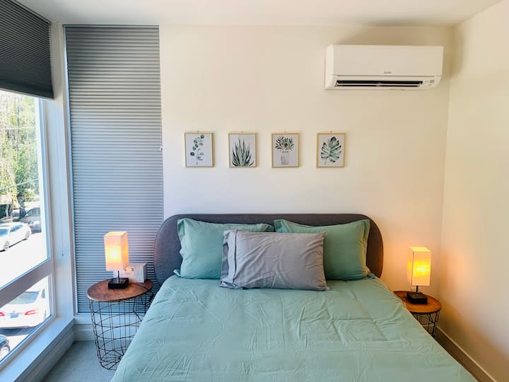 Cómoda cama tamaño queen con 2 mesas de noche en el dormitorio principal.