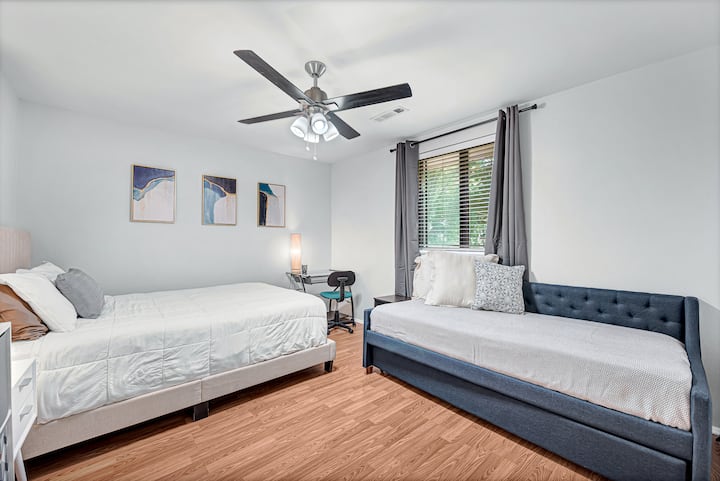 The second bedroom is huge! It has a workspace, queen bed, and daybed with a trundle