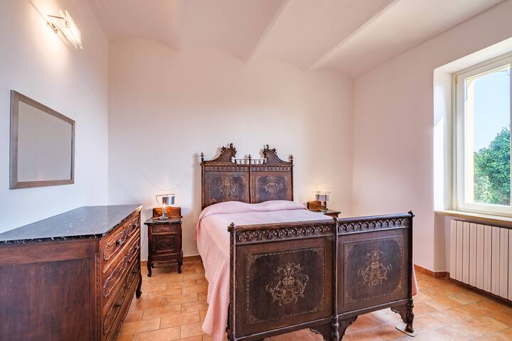 la chambre principale avec le lit en fer forgé des années 1800.