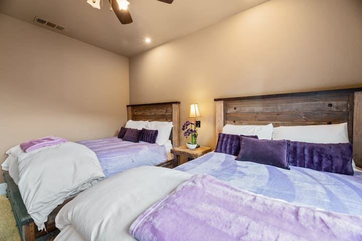 The Purple Room, or Bedroom 3, features two queen-sized beds, offering plenty of space and comfort. With vibrant purple tones and cozy accents, it’s a relaxing retreat for a restful night’s sleep or a peaceful getaway.







