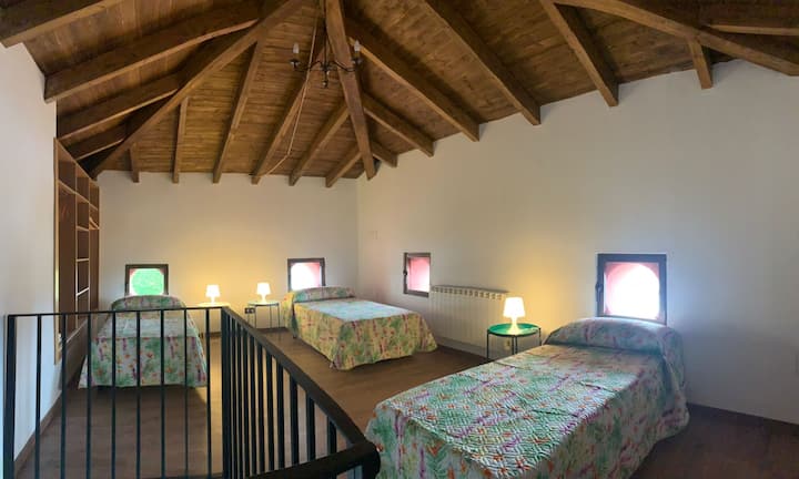 Dormitorio 2, en la planta superior de la vivienda, con tres camas individuales y un armario empotrado.