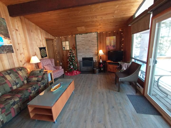 Salon avec foyer au bois, jeux et télévision.