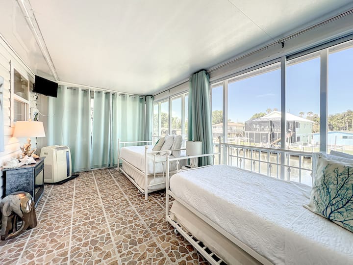 El tercer dormitorio tiene dos camas individuales que tienen dos camas nido adicionales a nivel del piso para dormir más. La mejor parte de esta habitación es que son las paredes de vidrio con vistas al canal. ¡Qué delicia despertarse con esa vista!