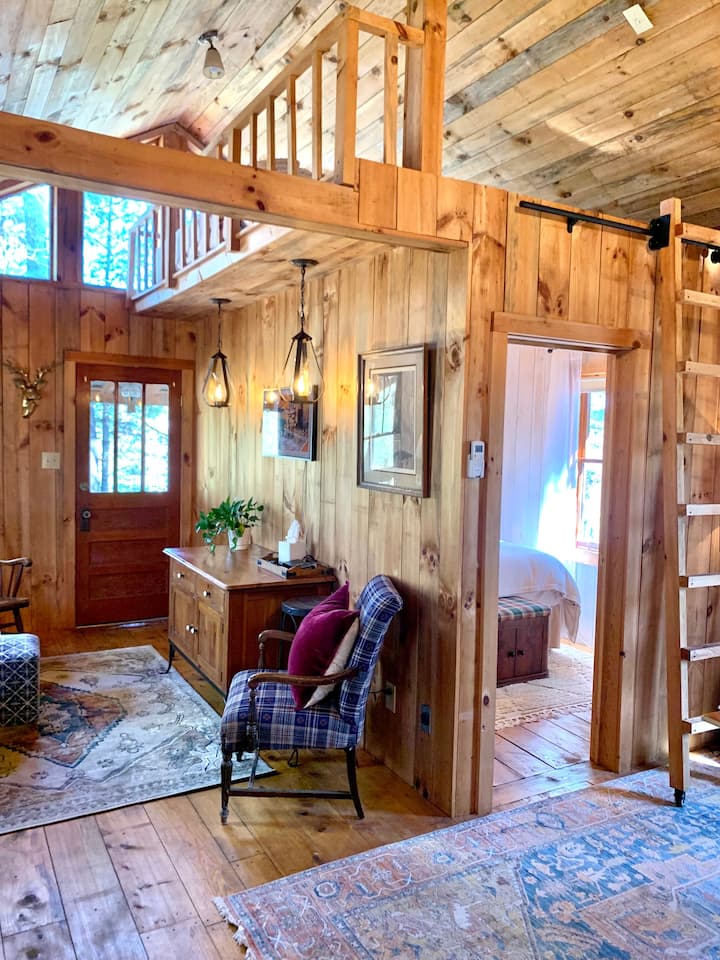Living space with a smart tv. Ladder leading to the loft space with king mattress. 