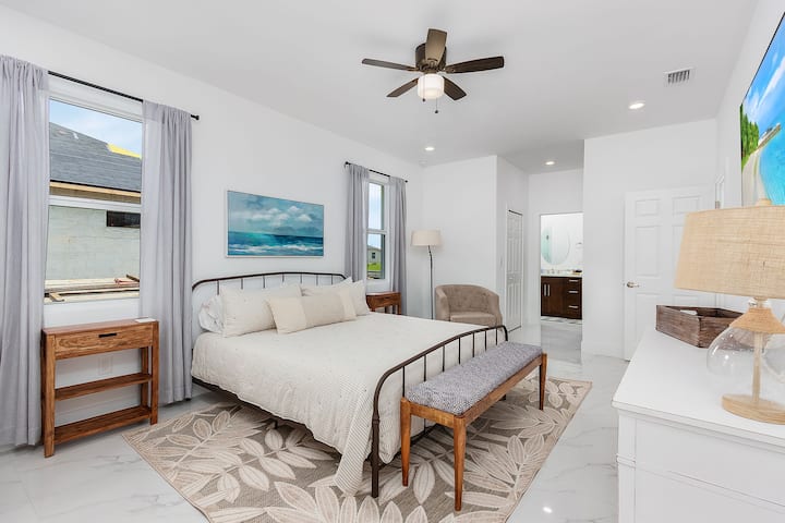 Chambre principale avec lit King Size, salle de bain privée avec accès direct et télévision grand écran.  Beaucoup de rangements dans les placards et les tiroirs pour vos séjours prolongés !