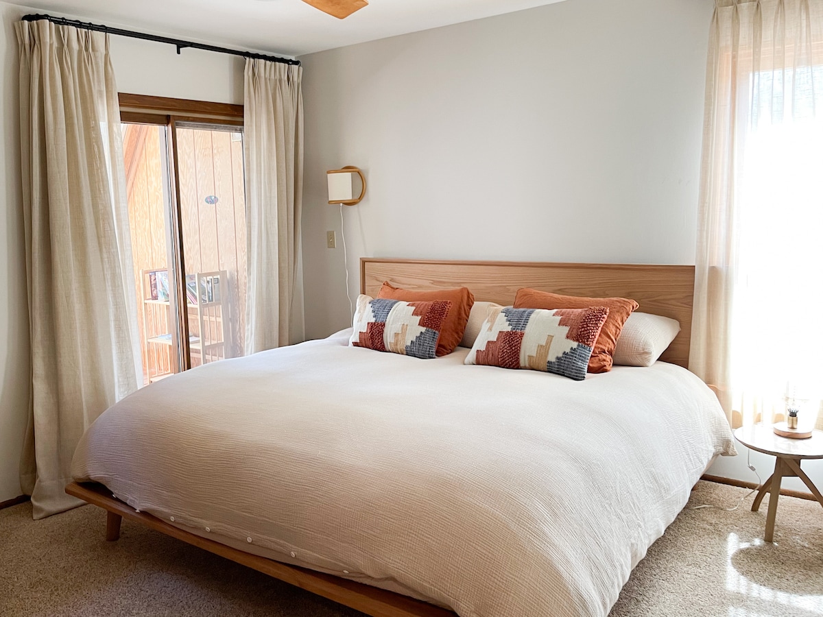 غرفة نوم رئيسية مع سرير بمقاس كبير مغطى بأكثر الأسرّة المنزلية راحة للمظلة