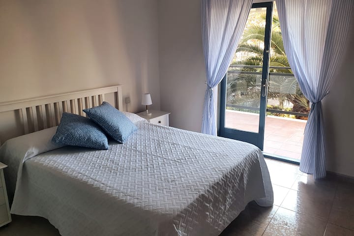 Dormitorio principal con cama doble de 150x200, y salida directa al amplio balcón exterior.