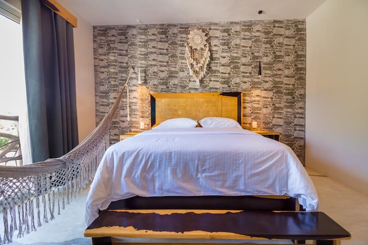 房间配有标准双人床、深色窗帘和家具的自然色调。