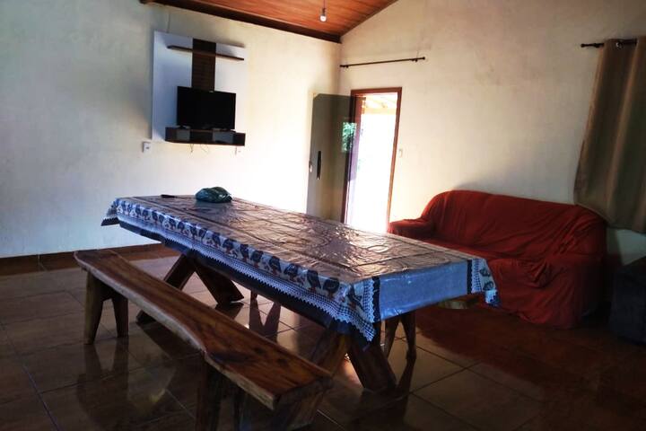 Salon avec 2 canapés, télévision et une grande table à manger.