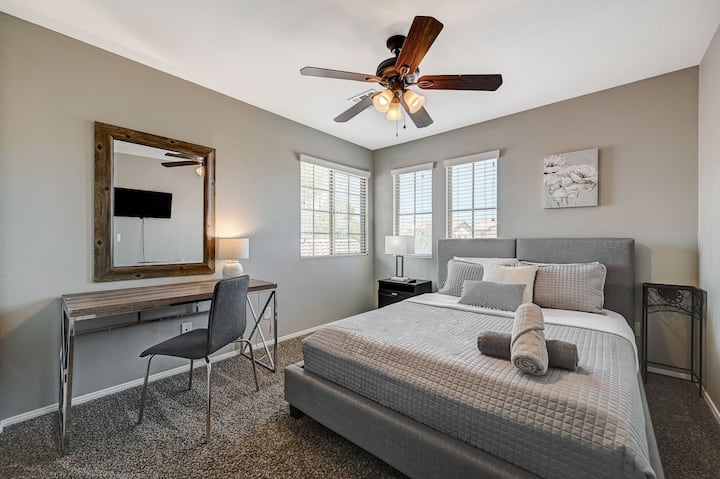 Dormitorio n.º3 situado en la planta superior, cama tamaño queen, TV inteligente, mesitas de noche, escritorio con espejo y cómoda alta.