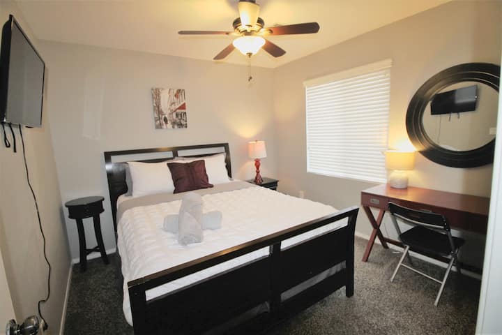 Dormitorio n .º2 situado en la planta superior, equipado con cama tamaño queen, TV inteligente, escritorio con espejo, 2 mesas de noche y cómoda alta en el armario.