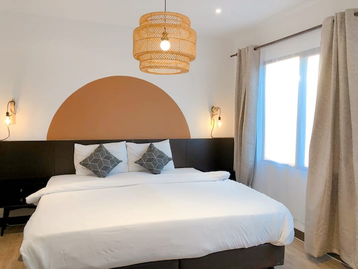 Prirodzené svetlo prúdiace cez okná vytvára príjemnú a príjemnú atmosféru v tejto hlavnej spálni inšpirovanej hygge.