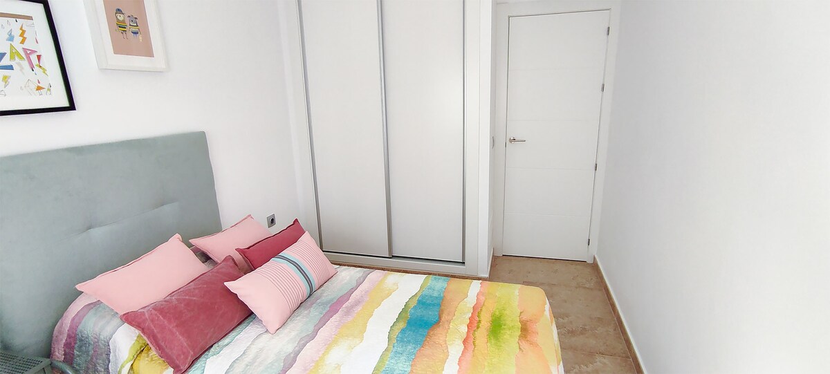 De tweede slaapkamer met een comfortabel tweepersoonsbed en een ingebouwde kledingkast.