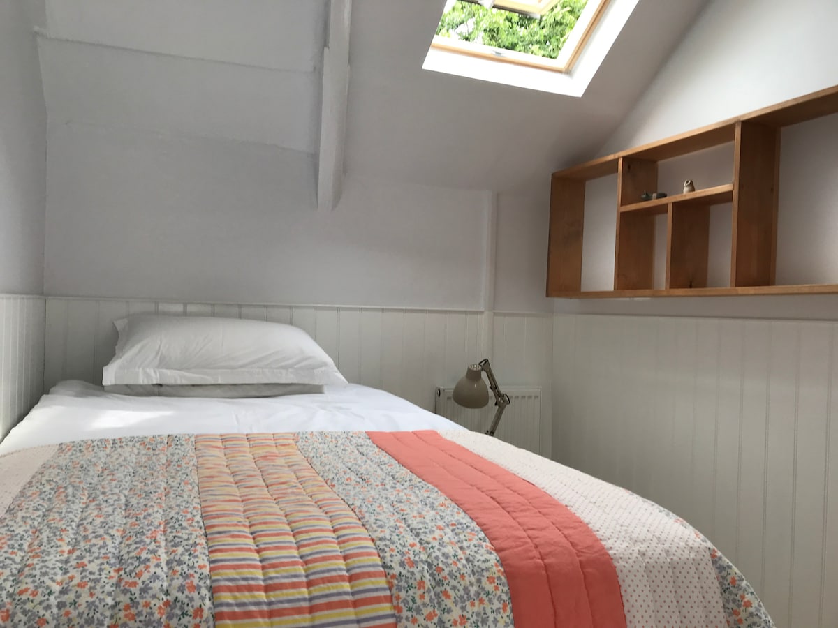 小木屋卧室，配有小双人床和天窗