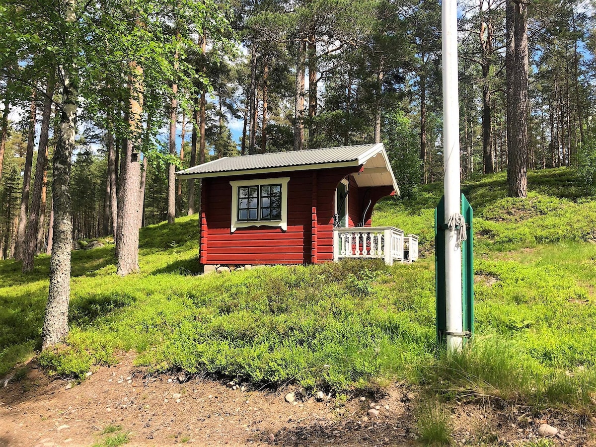 A narrow double bed and table and chair a cozy room
